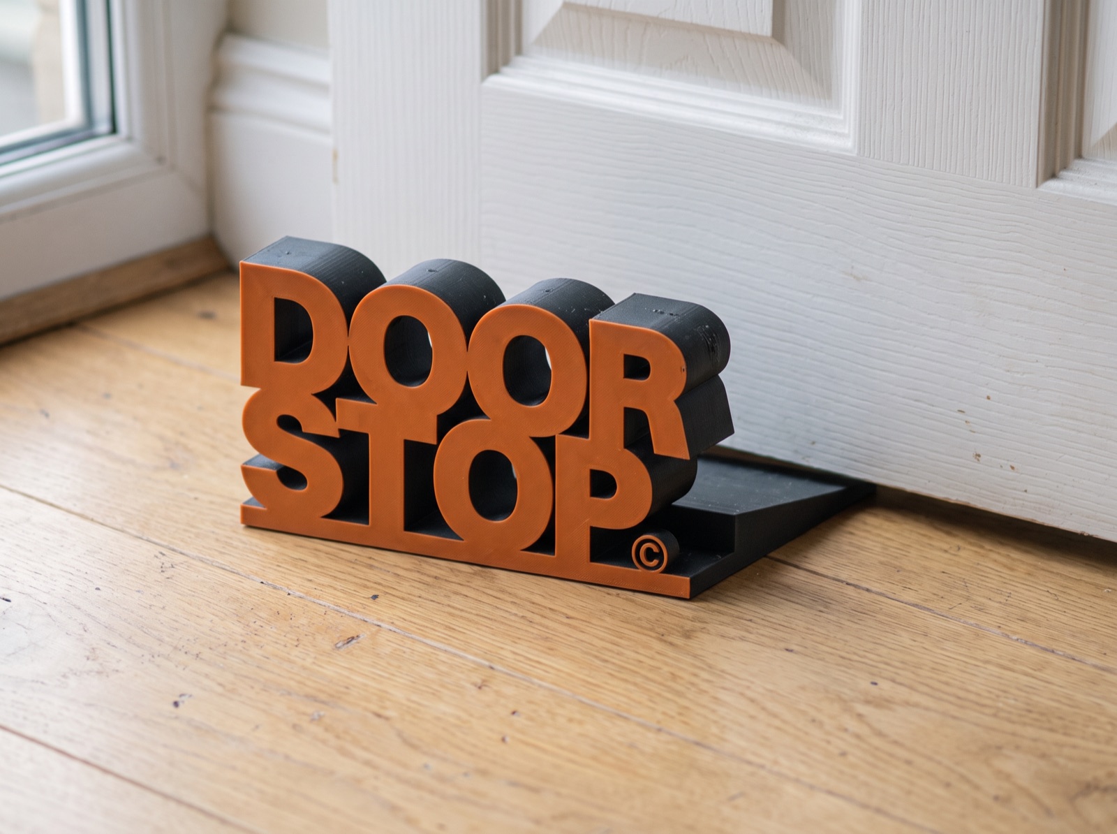 DOOR STOP under the door, seen from the hinge side near a window